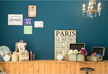青緑の壁にレトロなポスター、本、小さなシャンデリアがる、あたたかみのある雰囲気の「マイブライド尾張旭」のフォトスタジオ