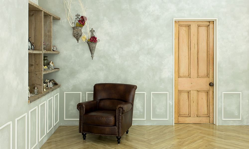 グレーの壁面にゆったりとした椅子や小さな小物が設置された、落ち着いた雰囲気の「マイブライド一宮」のスタジオイメージ