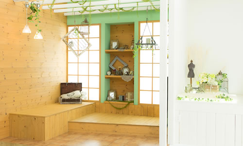 ウッド調で統一された壁面に明るいグリーンの差し色がある壁面に、レトロな雑貨を配したあたたかい雰囲気の「マイブライド一宮」のスタジオ