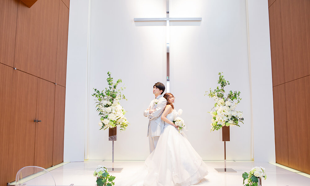純白の「マイブライド津」のチャペルで洋装フォトを撮影する花嫁と新郎のイメージ