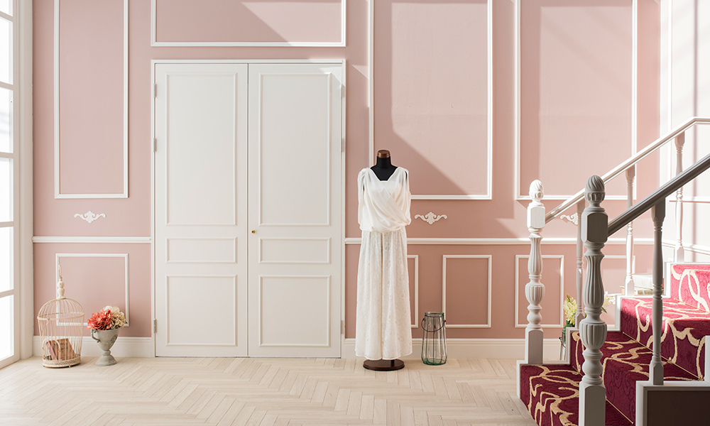 ピンク色の壁面に、白いトビラとヨーロッパ調の階段が特徴的な、「マイブライド津」のスタジオイメージ