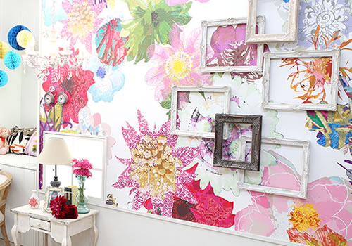 鮮やかな色の花々が描かれた壁に、いろんな額が飾られたアーティスティックな雰囲気のある「マイブライド尾張旭」のスタジオイメージ