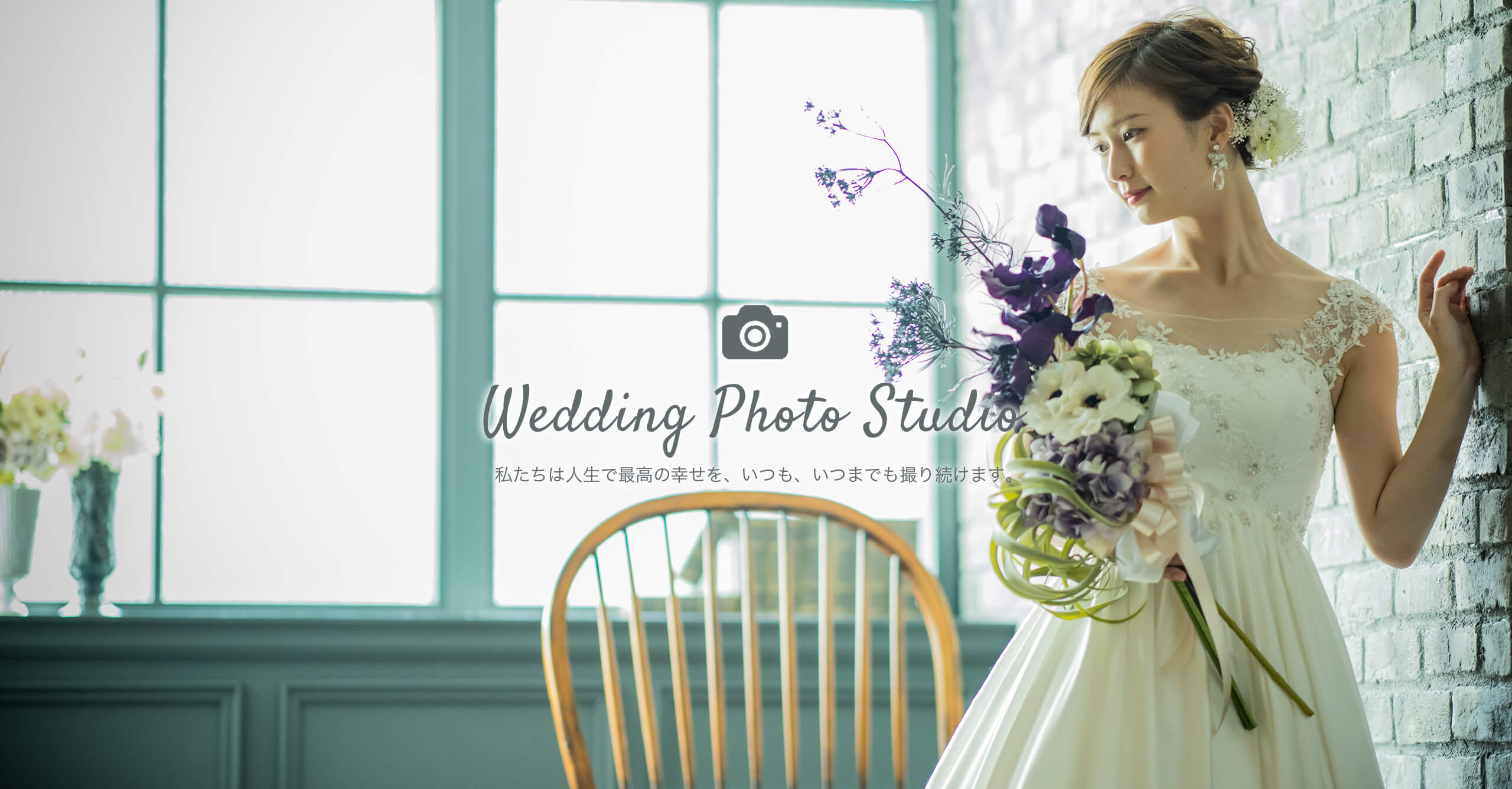 レンガ造りの壁を背に、白のウェディングドレスを着て、鮮やかな色の花のブーケを持って立つ花嫁のフォトウェディングのイメージ｜～Wedding Photo Studio～ 私たちは人生で最高の幸せを、いつも、いつまでも撮り続けます。